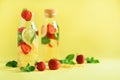 Fresh fruit flavored water with strawberry, lemon, mint on yellow background. Summer drink concept. Copy space. Infused Royalty Free Stock Photo