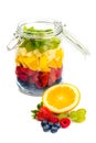 Fresh fruit in front of glass jar full of colorful fruits