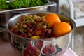 Fresh fruit grapes, orange in a silver bowl. Fresh greens, lettuce in the background