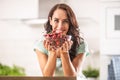 Fresh fruit harvest in the form of cherries in a seethrough bowl held by a woman indoors