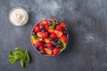 Fresh fruit salad with different ingredients with mint and sour cream on dark background. Healthy diet. Copy space for Royalty Free Stock Photo