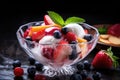 Fresh fruit salad with ice cream in glass bowl on black background. Royalty Free Stock Photo
