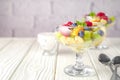 Fresh fruit salad on a light wooden table background