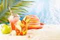 Fresh fruit salad in transparent takeaway box with cold cocktail, green apple on tropical summer beach with palm, sand, sunny sea. Royalty Free Stock Photo