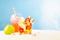 Fresh fruit salad in transparent takeaway box with cold cocktail, green apple on tropical summer beach with white sand, sunny sea. Royalty Free Stock Photo