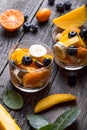 Fresh fruit salad with various kind of berry and citrus fruit, mango served in glass bowl, placed on wooden table. Shot from Royalty Free Stock Photo