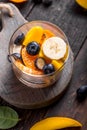 Fresh fruit salad with various kind of berry and citrus fruit, mango served in glass bowl, placed on wooden table. Shot from Royalty Free Stock Photo