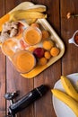 Fresh fruit smoothie with banana and apricots at orange  tray  with blender  at wooden table. flat lay Royalty Free Stock Photo