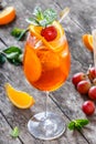 Fresh fruit tropic cocktail with mint, orange and grapes in tall glass on wooden background. Summer drinks and alcoholic cocktails