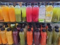 Fresh fruit and vegetable juice and coconut water in clear bottles, on a shelf in a market Royalty Free Stock Photo