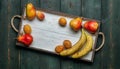 Fresh fruit on a white wooden tray: banatas, pears, apricots. Countryside setting. Top view. Royalty Free Stock Photo