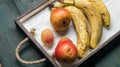 Fresh fruit on a white wooden tray: banatas, pears, apricots. Countryside setting. Top view. Royalty Free Stock Photo