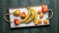 Fresh fruit on a white wooden tray: banatas, pears, apricots. Countryside setting. Top view. Royalty Free Stock Photo