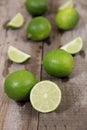 Whole limes with lime slices on wooden table