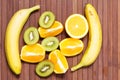 Fresh fruits banana, kiwi, orange isolated on wooden background. Healthy food. A mix of fresh fruit. Group of citrus fruits.