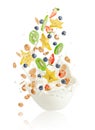 Fresh fruits, berries, corn flakes and nuts falling into the bowl with splashing milk. Healthy muesli breakfast Royalty Free Stock Photo