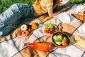 Fresh Fruits and berries, drinks and bakery on picnic blanket outdoor, summer vacation, woman lying on picnic blanket Royalty Free Stock Photo