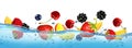 Fresh fruits and berries splashing in water waves with air bubbles and sunbeams. Royalty Free Stock Photo