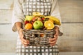 Fresh fruits bucket holded by adult woman with wall background - concept of weight loss and fruit store commerce - agriculture and