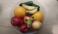 fresh fruits and cucumbers in a large transparent bowl on a wooden table Royalty Free Stock Photo