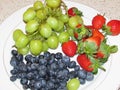 Fresh fruits on a plate on white background. Royalty Free Stock Photo