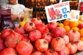 Fresh fruits pomegranates and oranges on counter of local market with price tags for preparing juice