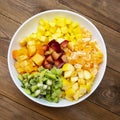 Fresh fruits salad glass bowl - mango, citrus, kiwi fruit, plum and persimmon. Healthy food. Square image Royalty Free Stock Photo