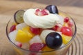 fresh fruits salad on glass bowl with wooden background