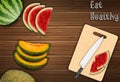 Fresh fruits slices on the table with a knife and watermelon on a cutting board background Royalty Free Stock Photo