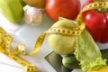 Fresh fruits and vegetables, measuring tape,  dumbbell  on white  scales Royalty Free Stock Photo