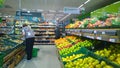 Fresh fruits and vegetables on supermarket shelves. Retail industry. Customers choose products. Pears and apples. Grocery shopping