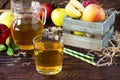 Fresh fruity apple juice and ripe apples on a wooden table. The concept of nutrition for superfoods and health or detoxification