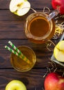 Fresh fruity apple juice and ripe apples on a wooden table. The concept of nutrition for superfoods and health or detoxification.