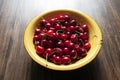 Fresh garden cherries in yellow ceramic bowl on wooden table. Summer harvest. Delicious red berries. Royalty Free Stock Photo