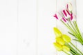 Fresh garden multicolored tulips on white wooden table