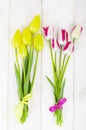 Fresh garden multicolored tulips on white wooden table