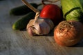 Fresh garden vegetables - garlic, onion, zucchini, tomatoes, cucumber on a light wooden background Royalty Free Stock Photo