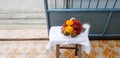 Fresh garland flower with rambutan, dragon fruit and glass of water on table with blue stainless steel fence