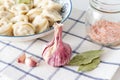 Fresh garlic and bay leaf on the background of a plate with dumplings. Royalty Free Stock Photo