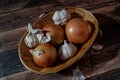 Fresh garlic bulbs and a garlic press on an old wooden board and a burlap backing Royalty Free Stock Photo