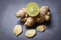 Fresh ginger root on dark background with sliced ginger and lemon lime Royalty Free Stock Photo