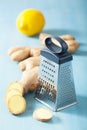 Fresh ginger root and grater over blue Royalty Free Stock Photo
