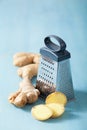 Fresh ginger root and grater over blue Royalty Free Stock Photo