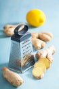 Fresh ginger root and grater over blue Royalty Free Stock Photo