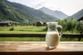 Fresh glass of milk on wooden table with summer mountains on background. illustration of healthy rustic lifestyle