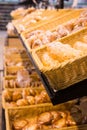 Fresh golden breads with melted cheese wrapped in plastic wrap in wicker basket in bread department of supermarket Royalty Free Stock Photo