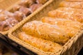 Fresh golden breads with melted cheese wrapped in plastic wrap in wicker basket in bread department of supermarket Royalty Free Stock Photo