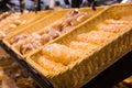 Fresh golden breads with melted cheese wrapped in plastic wrap in wicker basket in bread department of supermarket Royalty Free Stock Photo