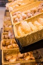 Fresh golden breads with melted cheese wrapped in plastic wrap in wicker basket in bread department of supermarket Royalty Free Stock Photo