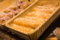 Fresh golden breads with melted cheese wrapped in plastic wrap in wicker basket in bread department of supermarket Royalty Free Stock Photo